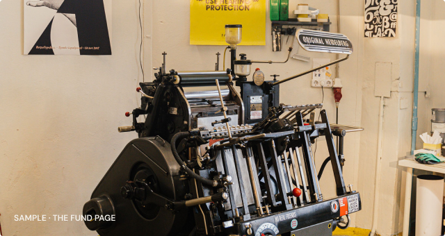 A letterpress workshop with a proof pinned above the bed