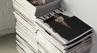 A stack of printed magazines on a studio table