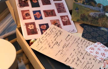 A box of hand-addressed letters and flower stamps